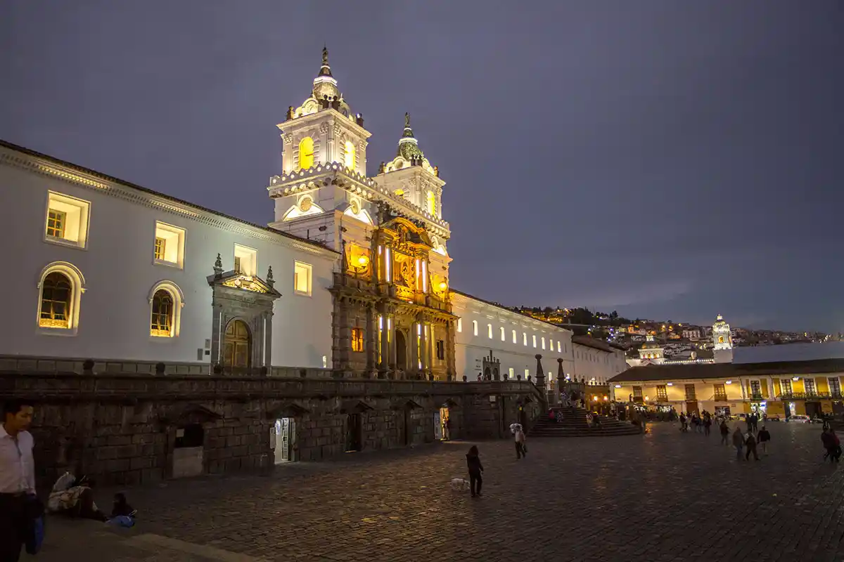 Illuminated San Francisco Plaza in Quito at night, a cultural gem on the Yacht Isabela II tour.