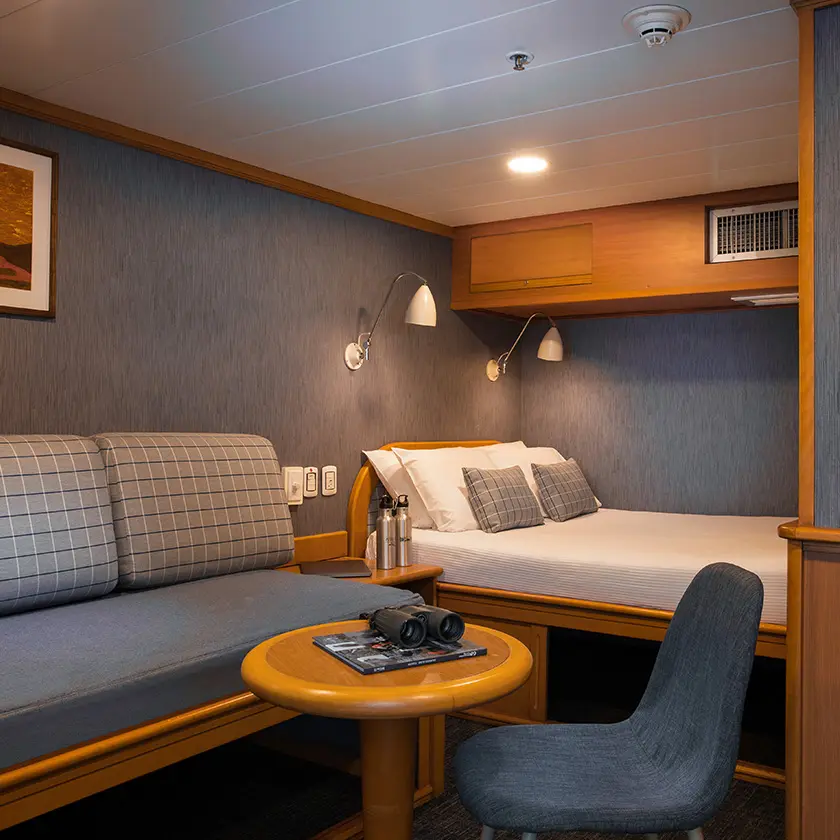 Cómoda y elegante cabina en el Yate Isabela II, que cuenta con ropa de cama confortable y comodidades modernas.