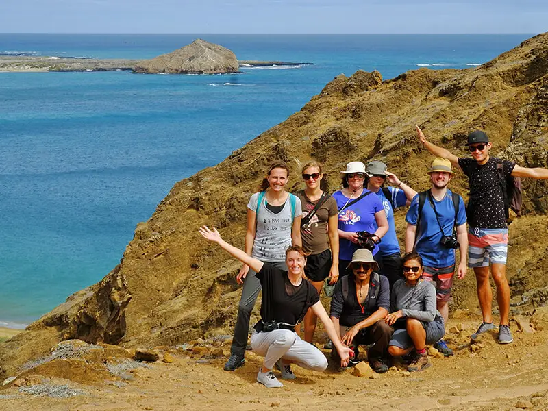 Exploradores felices en Punta Pitt, San Cristóbal, disfrutando de una excursión en el Yate Isabela II.
